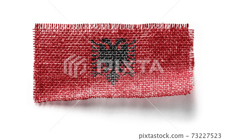 Albania flag on a piece of cloth on a white background 73227523
