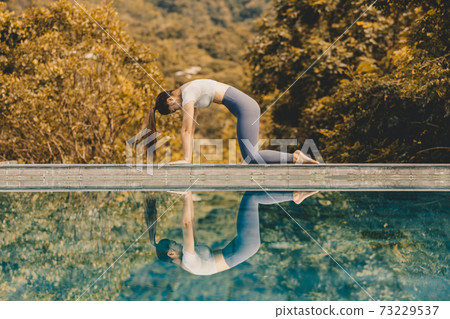 Calm of Athlete Attractive Asian woman relaxing in yoga Cat Cow Pose on the pool above the Mountain peak in front of beautiful nature views,comfortable and relax in vacations Calm of Athlete Attractive Asian woman relaxing in yoga Cat Cow Pose on the pool above the Mountain peak in front of beautiful nature views,comfortable and relax in vacations 73229537