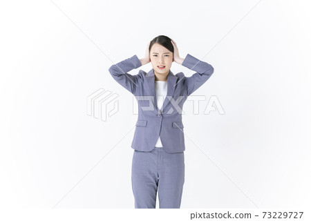 閉上她的耳朵的年輕商業女人 閉上她的耳朵的年輕商業女人 73229727