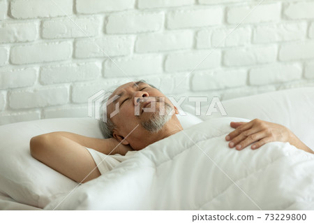 Asian Elderly man close eyes smile sleep and sweet dream on bed in bedroom in the morning feeling so relax and comfortable,Healthcare and Sleep Concept 73229800