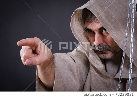 A fierce monk-man with a beard is pointing somewhere. A fierce monk-man with a beard is pointing somewhere. 73229851
