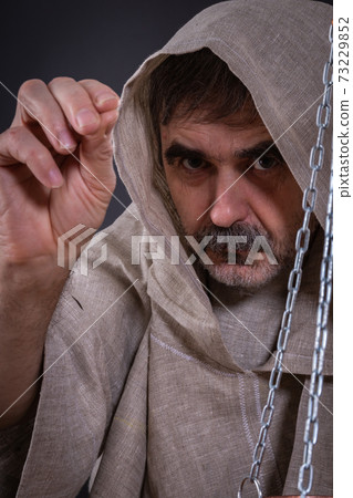 Elder monk blesses the cross 73229852