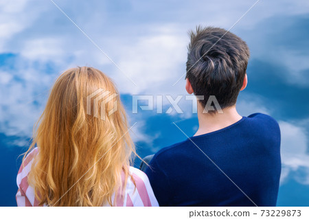 Loving young man and woman over blue sky with clouds 73229873