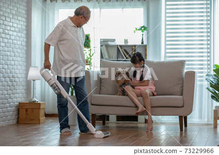 Asian Elderly senior man cleaning dust in living room by Wireless Vacuum cleaner Asian Elderly senior man cleaning dust in living room by Wireless Vacuum cleaner 73229966