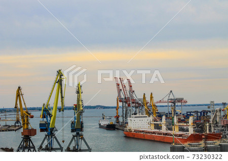 Hoisting cranes and industrial ships at cargo sea port in Odessa, Ukraine Hoisting cranes and industrial ships at cargo sea port in Odessa, Ukraine 73230322