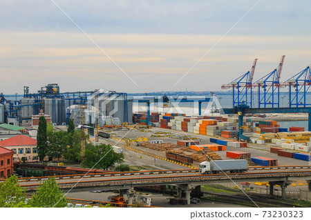 Hoisting cranes, transport containers and granaries at cargo sea port in Odessa, Ukraine Hoisting cranes, transport containers and granaries at cargo sea port in Odessa, Ukraine 73230323