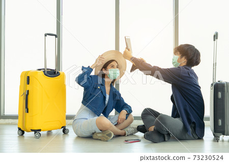 Couple love in airport using travel app on smart phone. Couple love in airport using travel app on smart phone. 73230524