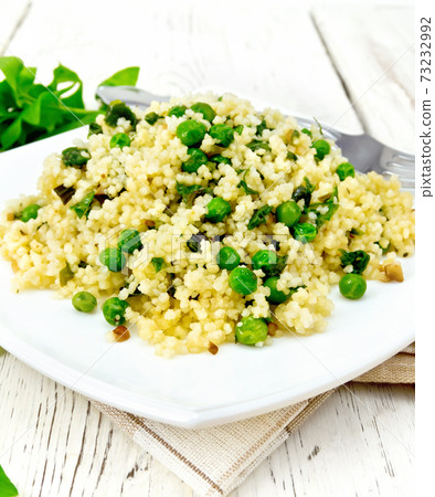 Couscous with spinach in plate on towel Couscous with spinach in plate on towel 73232992