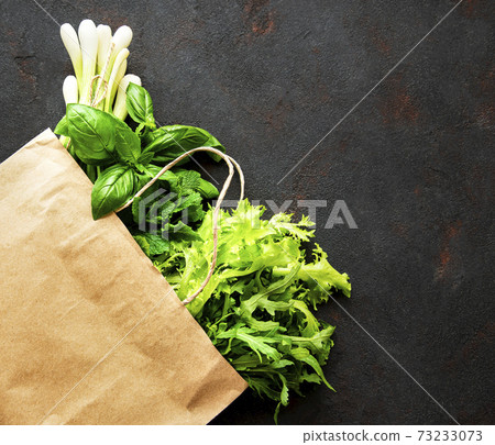 Fresh greens in a paper bag on a black background Fresh greens in a paper bag on a black background 73233073