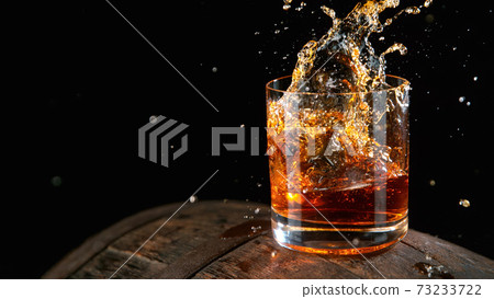 Whiskey Liquid falling into Glass 73233722