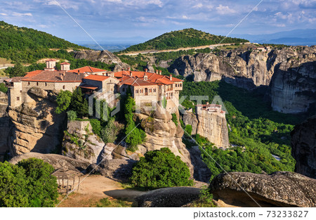 Cliff top Varlaam monastery, Meteora, Greece, typical landscape, rocky pillars. Moni Agias Varvaras Roussanou nunnery below. UNESCO World Heritage 73233827