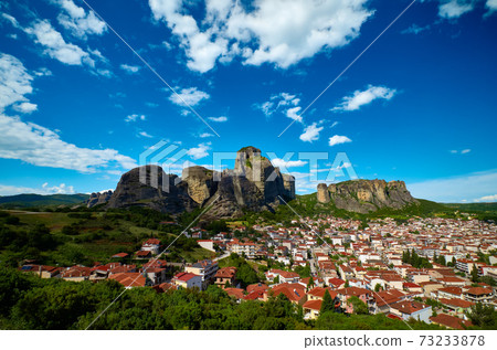 Meteora valley and mountains at day. Blue sky and great clouds over hills and villages of Kalampaka and Kastraki, Greece, UNESCO World Heritage. 73233878