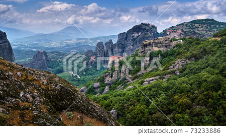 View of spectacular rocks of Meteora, Thessaly, Greece and valley. Nunnery of Moni Agias Varvaras Roussanou and Varlaam monastery. Rocky hills 73233886