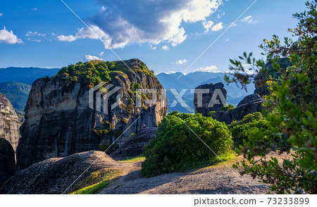 Evening view of typical Meteora landscape, Greece. Massive sedimentary rocks, cliffs, mountains, valley. Blue sky and great clouds. Selective focus. Evening view of typical Meteora landscape, Greece. Massive sedimentary rocks, cliffs, mountains, valley. Blue sky and great clouds. Selective focus. 73233899