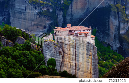 Close view of Moni Agias Varvaras Roussanou nunnery and spectacular massive rocky pillars of Meteora, Thessaly, Greece and rich foliage. 73233923