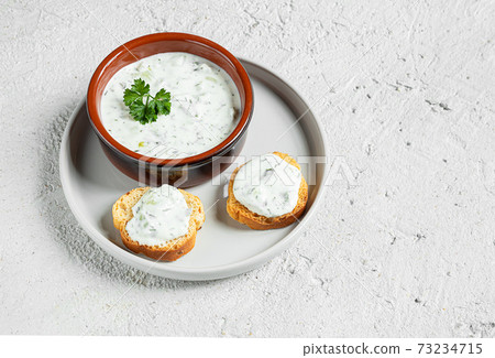 A bowl and crostini with tzatziki sause A bowl and crostini with tzatziki sause 73234715