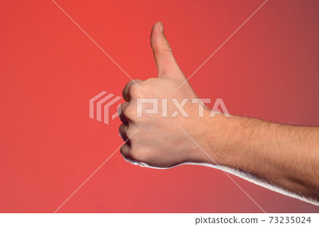 Close-up of a hand with a fingernail up of an isolated on a red background 73235024