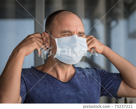 Man wearing facial disposable mask. Virus protection 73237221