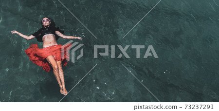 Aerial view of a woman in the sea 73237291