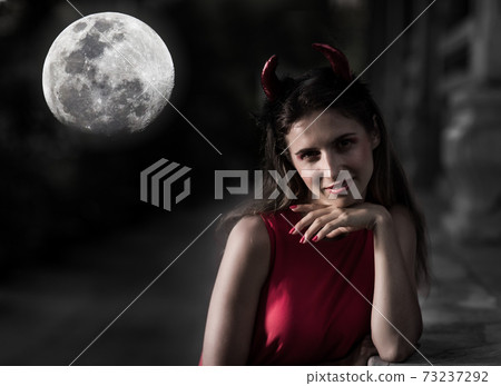 Beautiful woman in red dress and horns. Halloween Beautiful woman in red dress and horns. Halloween 73237292
