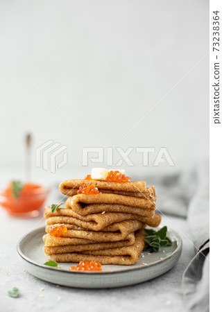 a stack of thin pancakes with red salted caviar and butter a stack of thin pancakes with red salted caviar and butter 73238364