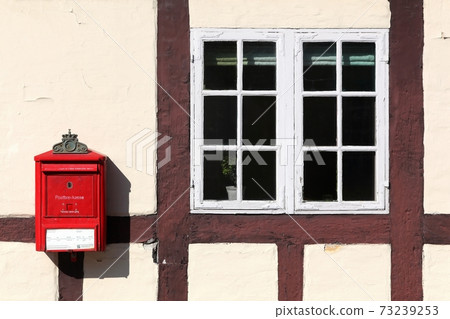Red danish letterbox on a wall in Odense, Denmark 73239253