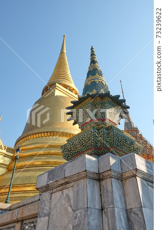 Gilded Buddhist temple of conical shape. Spiers of Asian religious buildings. Gilded Buddhist temple of conical shape. Spiers of Asian religious buildings. 73239622