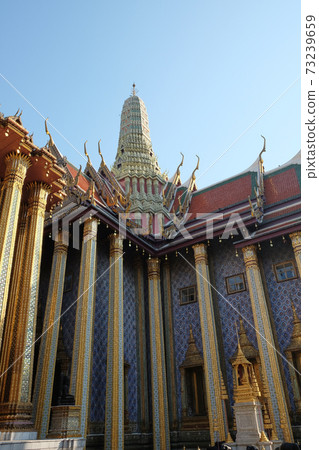 Fragment of the Temple of the Emerald Buddha in Bangkok with a colonnade and a spire. 73239659