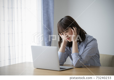 拿著她的在一台個人計算機前面的一個少婦頭 拿著她的在一台個人計算機前面的一個少婦頭 73240233