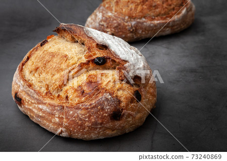 Sourdough bread with mixed fruits and nuts on dark cement background. Sourdough bread with mixed fruits and nuts on dark cement background. 73240869