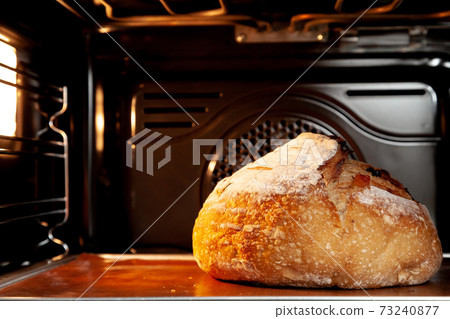 Baking sourdough bread in an oven. 73240877