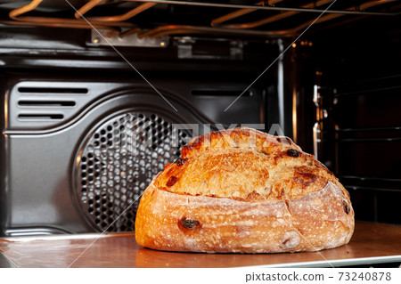 Baking sourdough bread in an oven. 73240878
