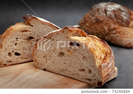 Sliced sourdough bread on dark cement background. 73240884