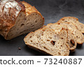 Sliced sourdough bread on dark cement background. 73240887