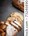 Sliced sourdough bread on dark cement background. 73240890