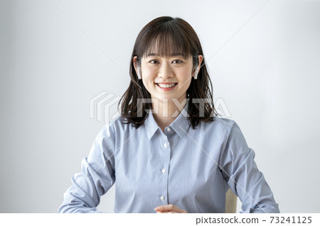 A young woman looking at the camera with wireless headphones A young woman looking at the camera with wireless headphones 73241125