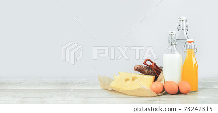 Meat and dairy produce with drinks in glass bottles. Food delivery 73242315