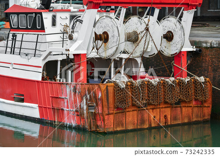 Rusty boat and nets for catching scallops 73242335