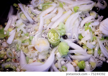 Onion stir fry with leek in frying pan 73244392