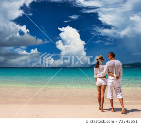 Couple in white on a beach 73245651