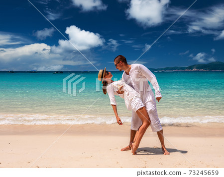 Couple in white having fun on a beach Couple in white having fun on a beach 73245659