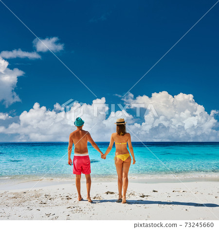 Couple walking on a tropical beach Couple walking on a tropical beach 73245660