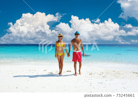 Couple walking on a tropical beach Couple walking on a tropical beach 73245661