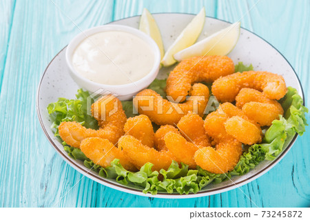 Shrimps in batter with sauce and lime 73245872
