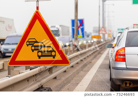 Traffic jam sign on a highway with line of cars waiting in row 73246693