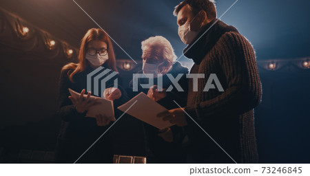 Elderly director supporting actors during quarrel scene 73246845