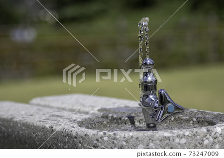 Water faucet facing up at the drinking fountain in the park 73247009