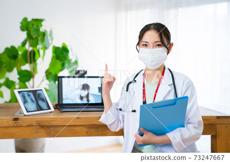 Young female doctor pointing at online practice 73247667