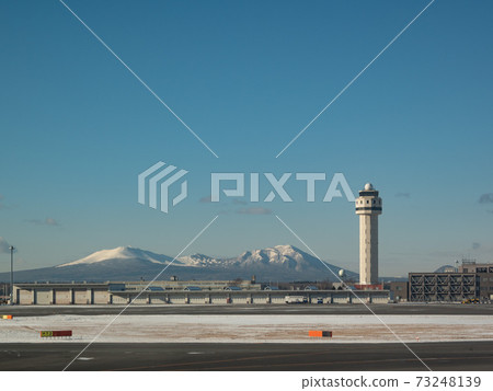 Snow-covered Mt. Tarumae and New Chitose Airport runway and control tower 73248139