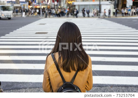 Back view of a woman standing at the Shibuya Scramble crossing 73253704